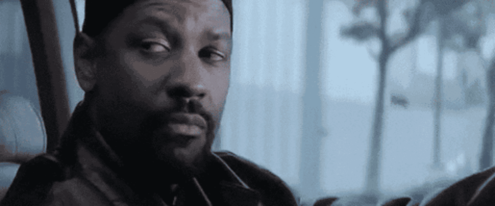 A GIF of Denzel Washington playing Alonzo Harris on Training Day laughs with a cigarette in his mouth