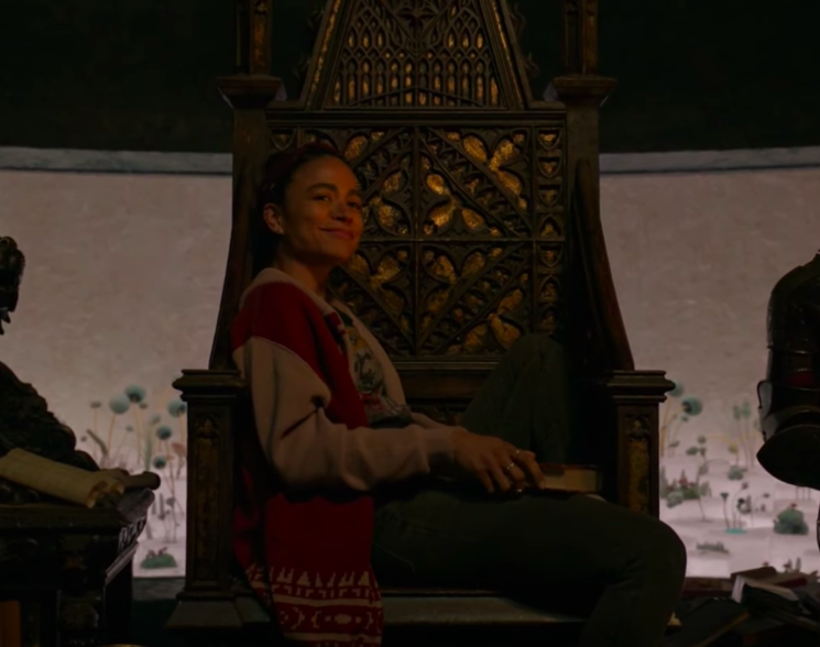 Lauren Ridloff sitting in a large chair in character