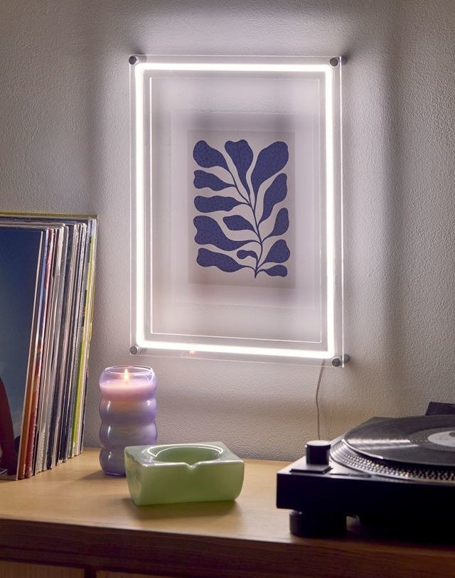 white neon rectangular frame around a print on a wall