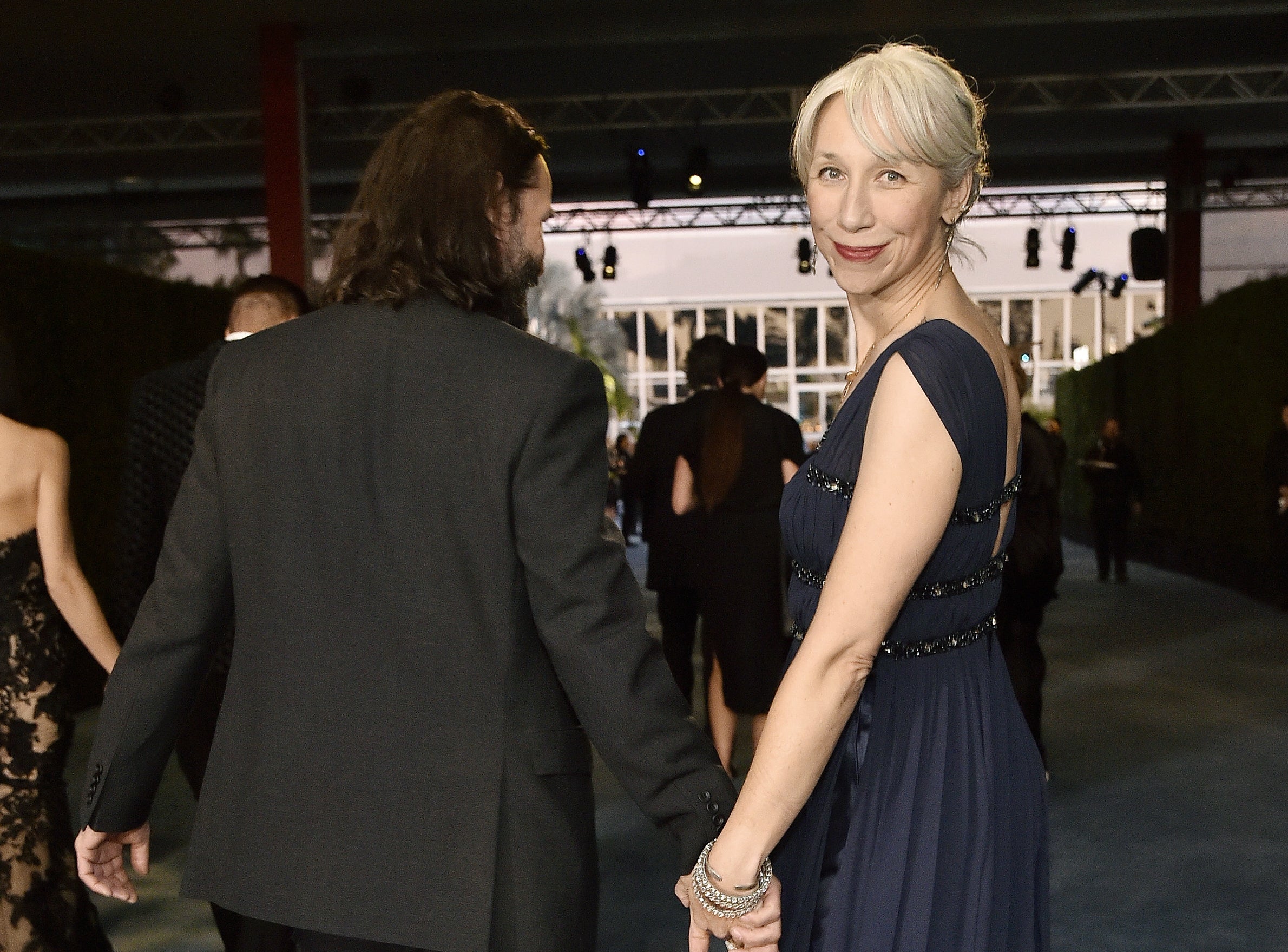 A closeup of Alexandra looking over her shoulder while walking away from the camera with Keanu