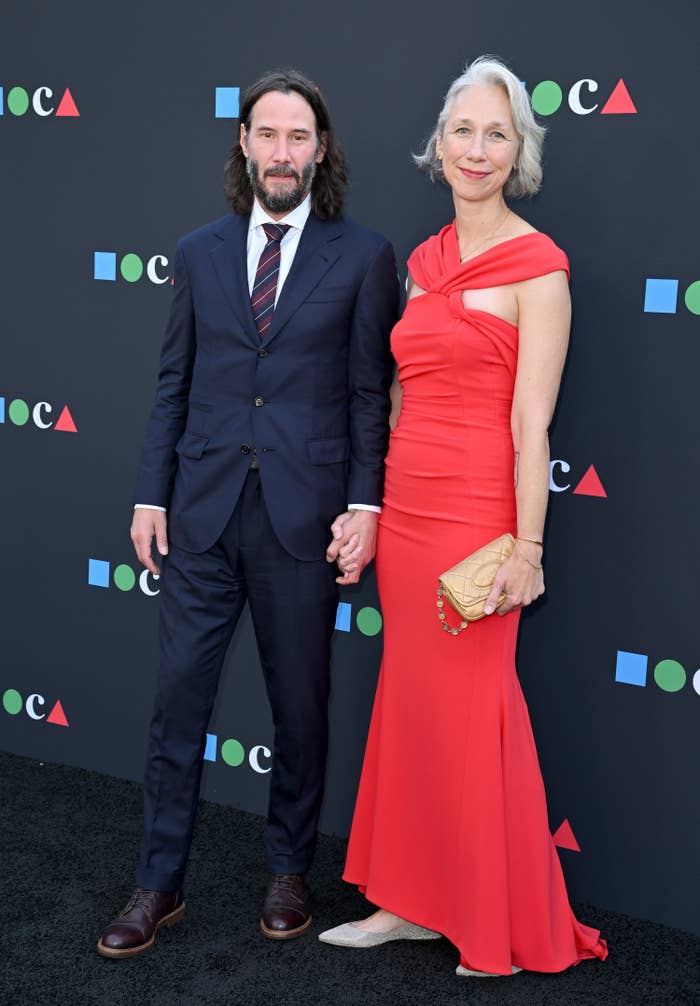 Keanu and Alexandra smile and hold hands