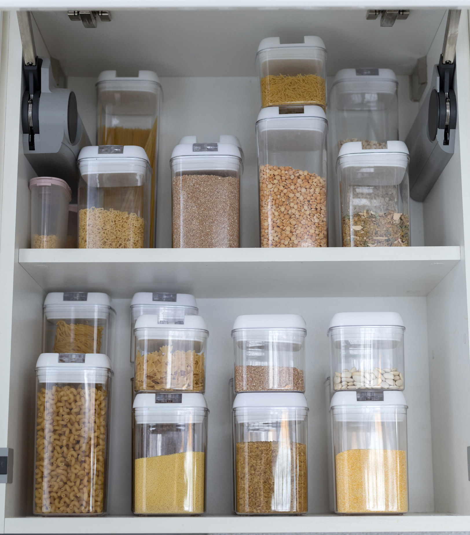 Food storage containers filled with cereals in the kitchen pantry.