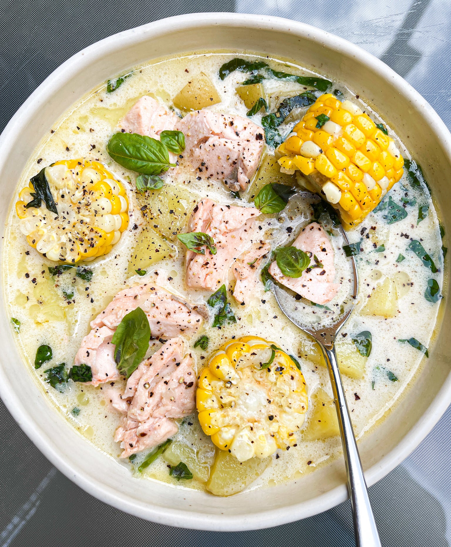 The final product, which is a bowl full of soup that as been sprinkled with pepper and basil leaves