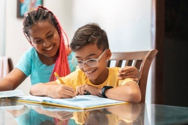 A foster mom helps her son complete his homework assignments