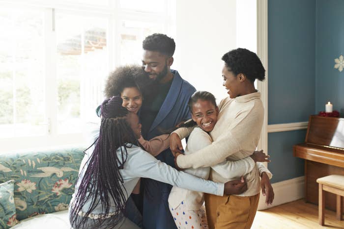 Parents receive big hugs from their three daughters