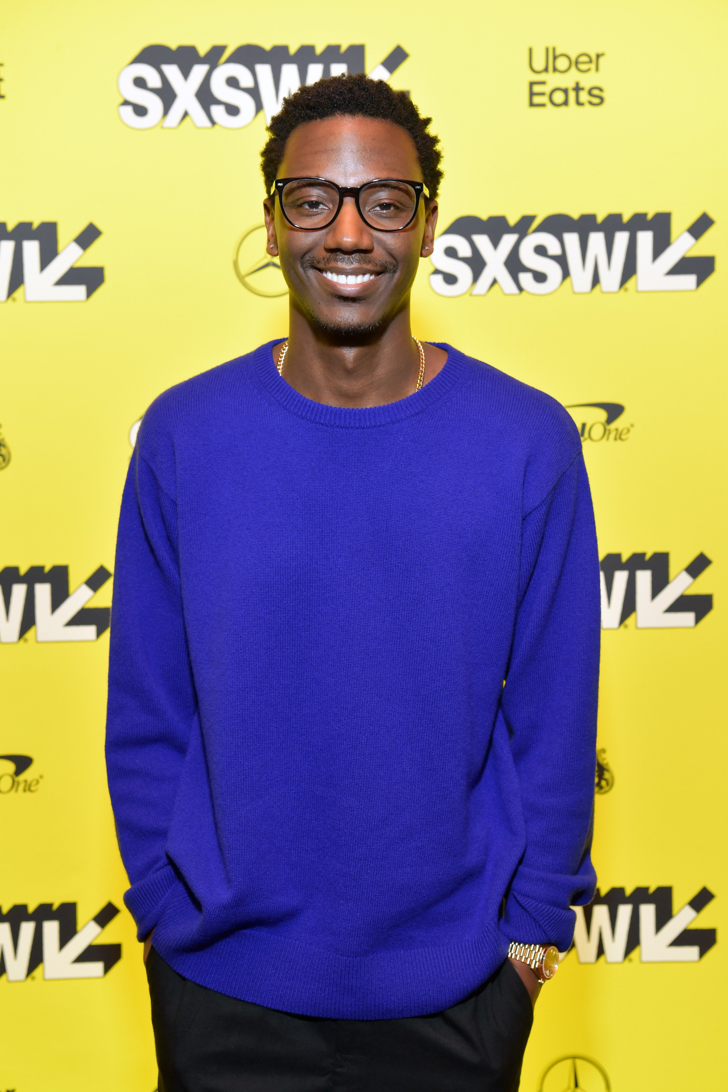 Jerrod Carmichael smiles with his hands in his pockets