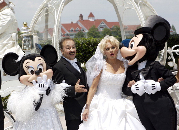 A bride and groom with Mickey and Minnie standing with them