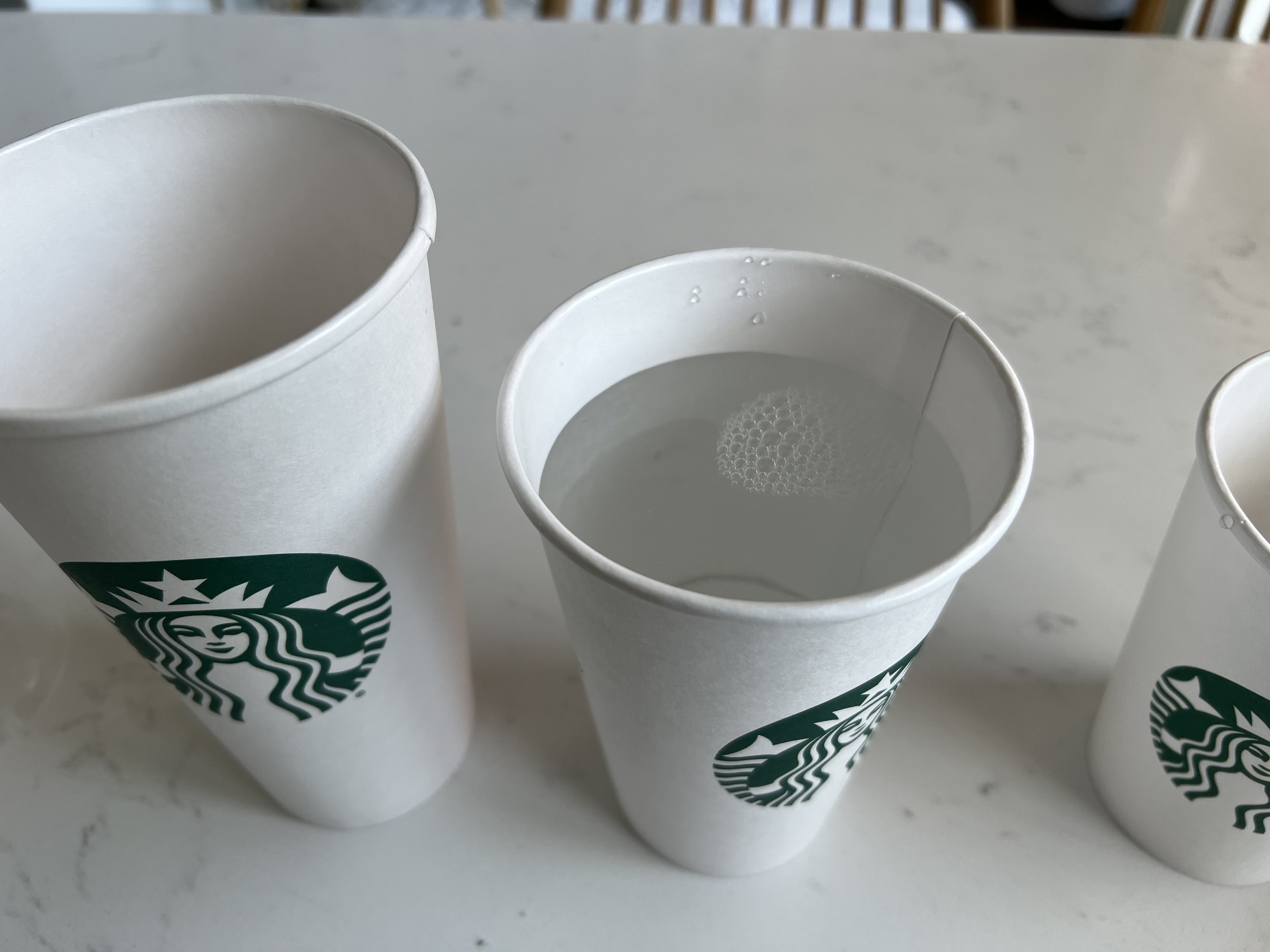 After pouring the water into the grande cup, the water level is about an inch or two below the top of the cup