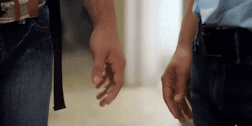 GIF two men holding hands and smiling before one walks away
