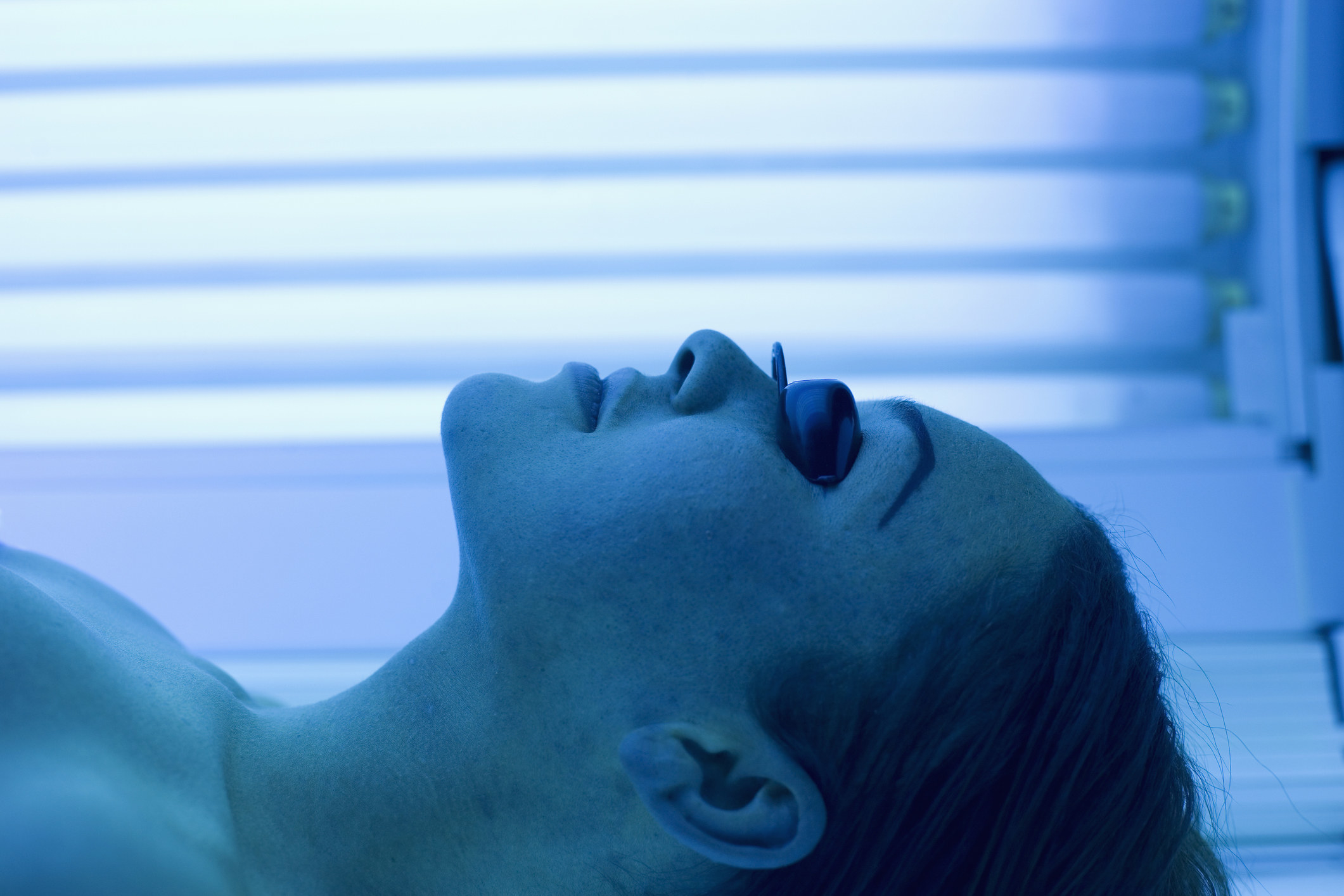 Woman lying in a tanning booth