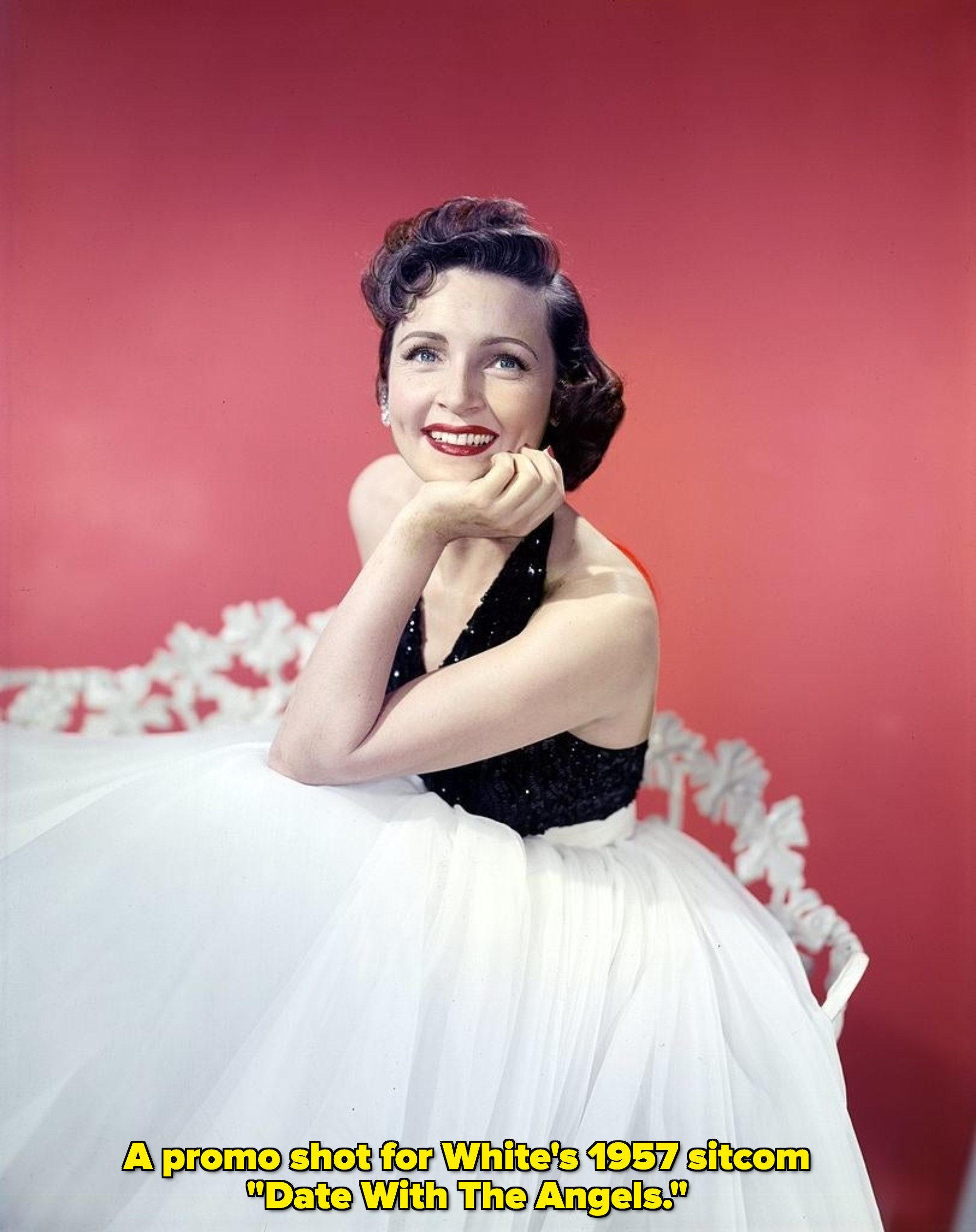 Betty White smiling in a gown in 1957