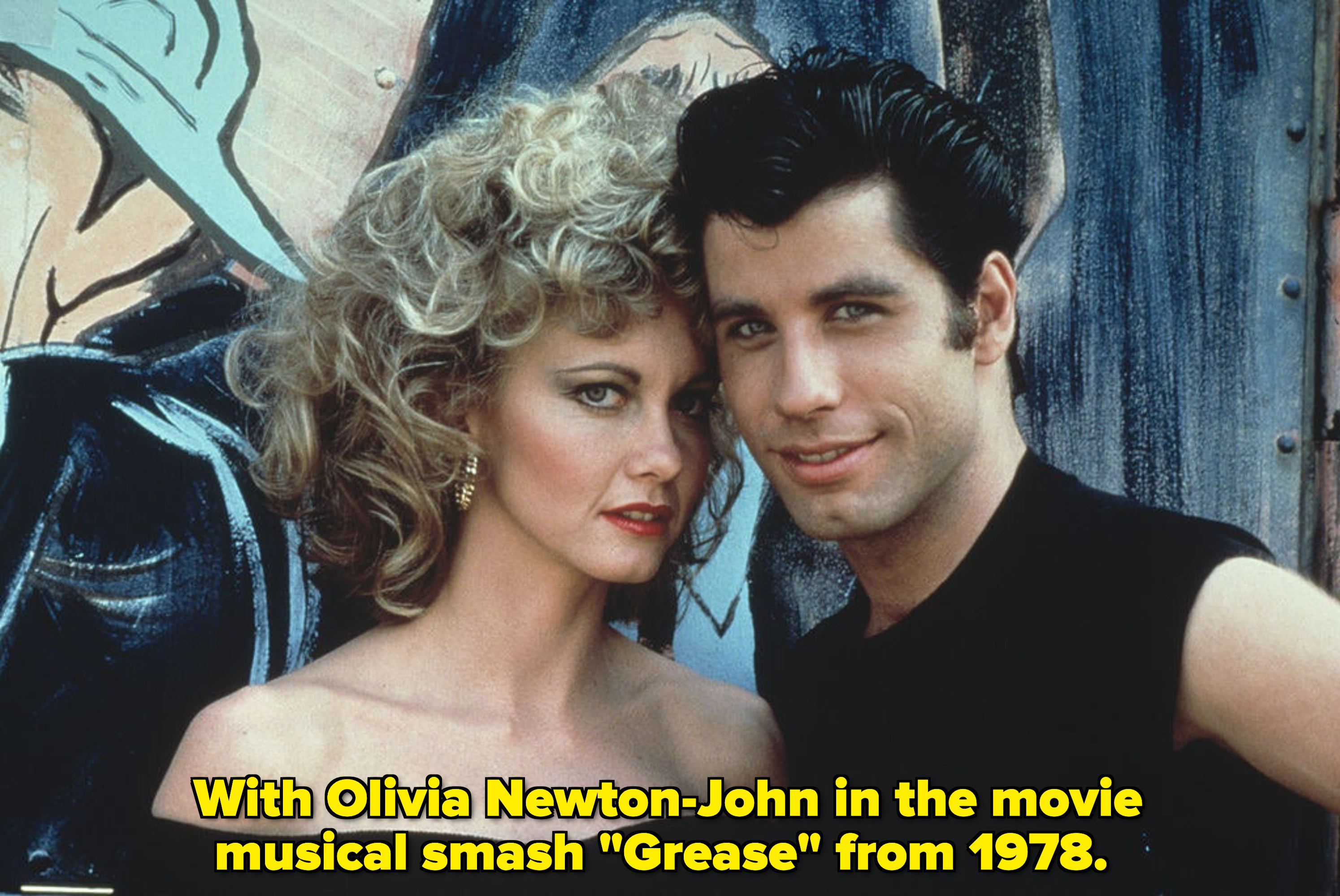 Olivia Newton-John and Travolta stand together and smile in &quot;Grease&quot;