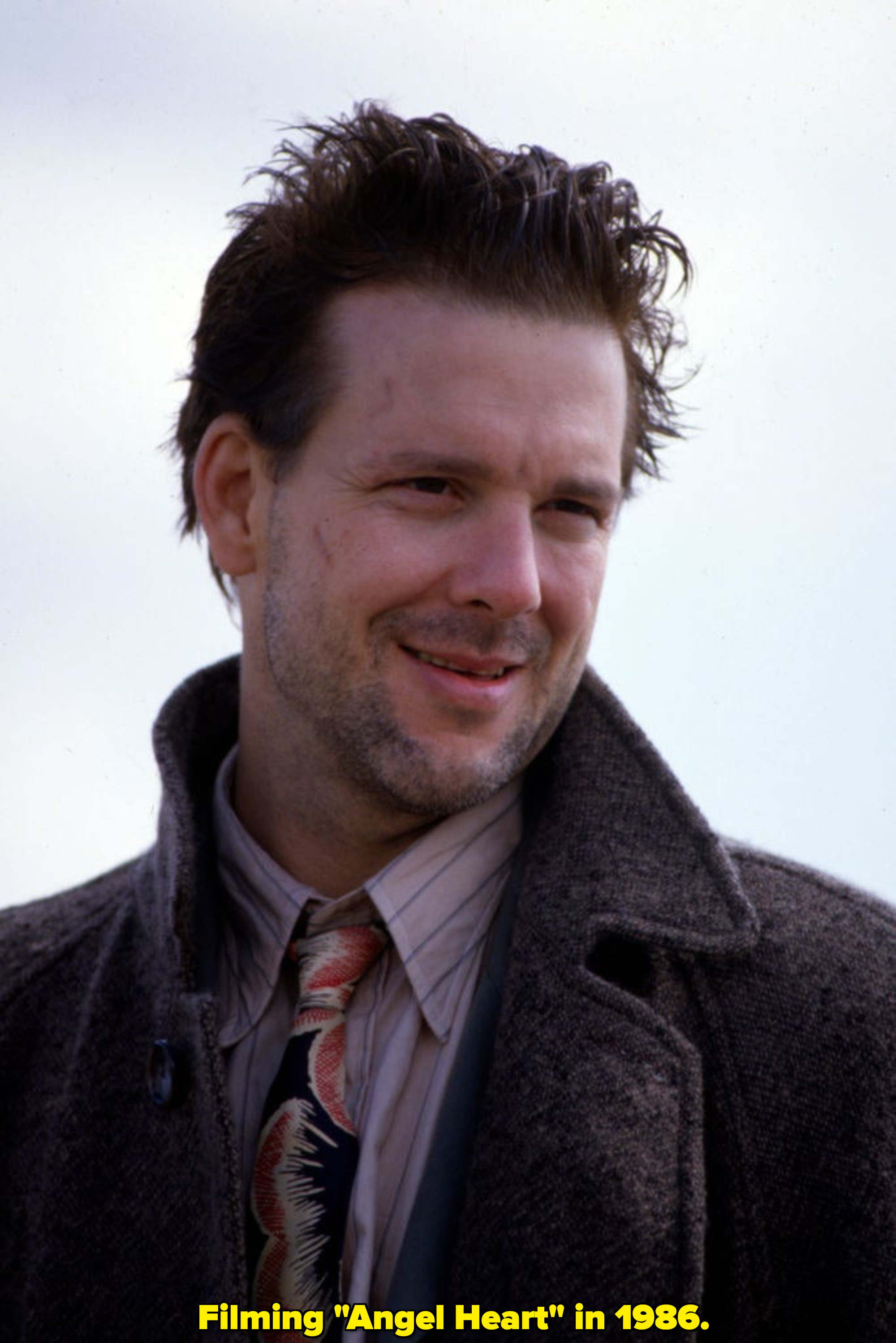 A young Mickey Rourke smiling in 1986