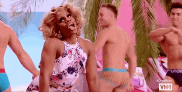 Monet X Change dancing with lots of shirtless guys in a scene from Drag Race