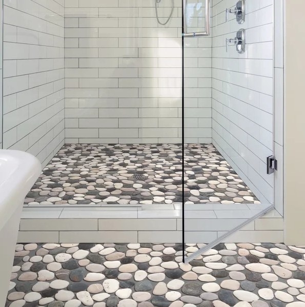 An image of some natural stone mosaic floor and wall tile on a shower floor
