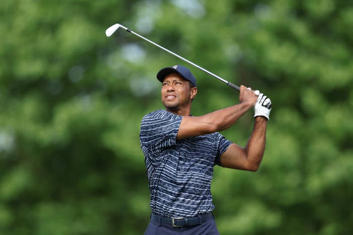 Tiger Woods looking at a golf ball after hitting it