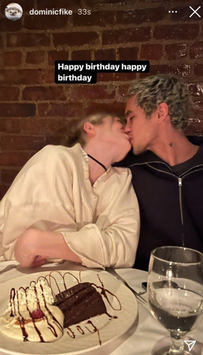 the couple kissing at a birthday dinner