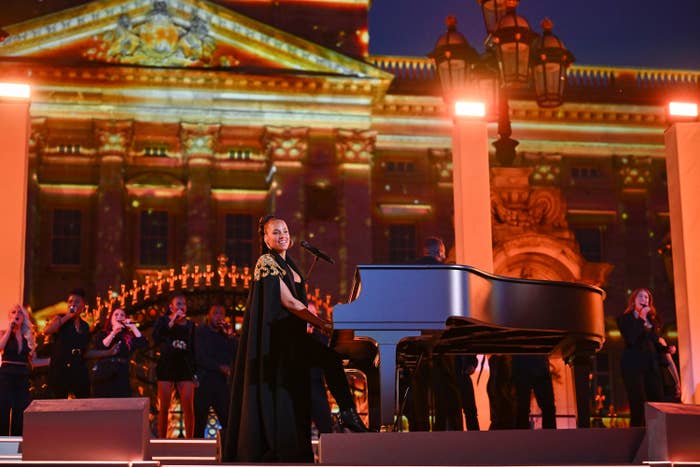 Alicia sits at her piano in front of the palace