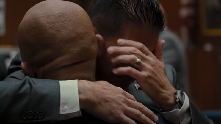A man holds another man, who&#x27;s crying, in a courtroom