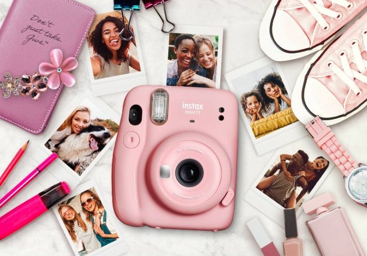 Pink instant camera with printed photos around it