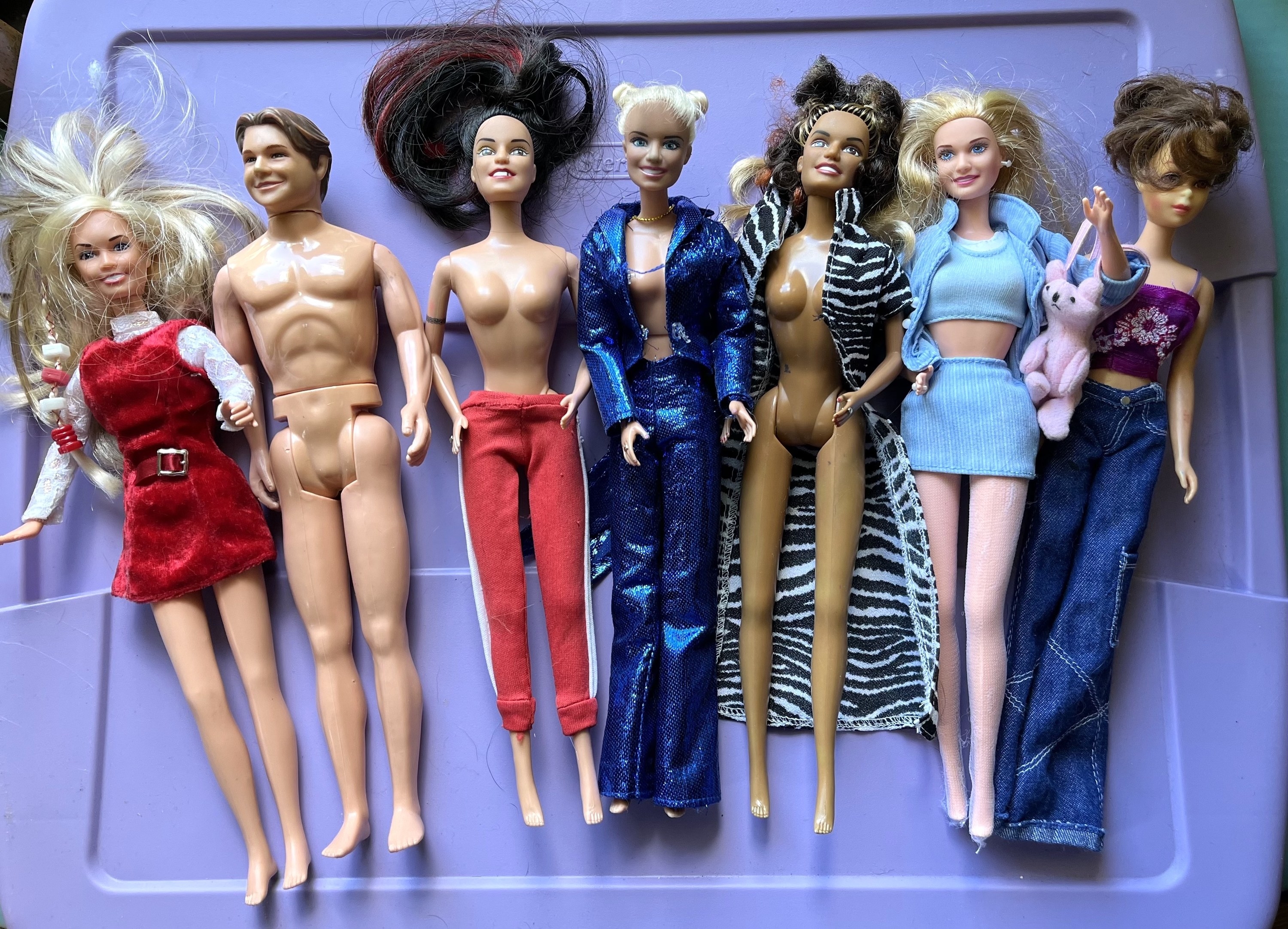 a line of barbies in different stages of being dressed