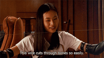 A woman holds a piano wire out in front of her, saying, &quot;This wire cuts through bones so easily&quot;