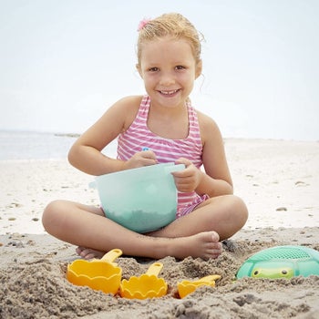 A child model playing with the toys on the beach