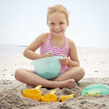 A child model playing with the toys on the beach
