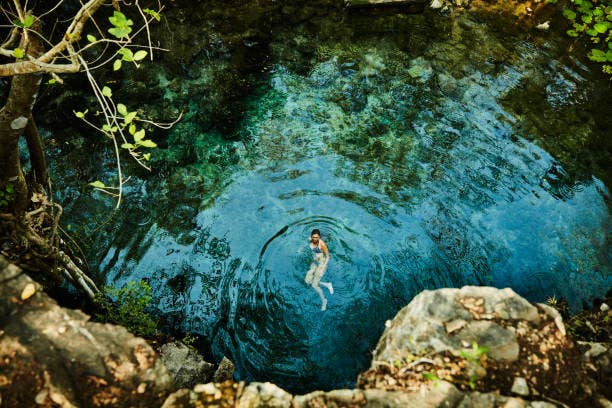 Women swimming alone in a cenote