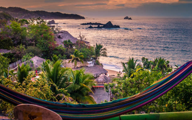 A colorful hammock in front of a beach