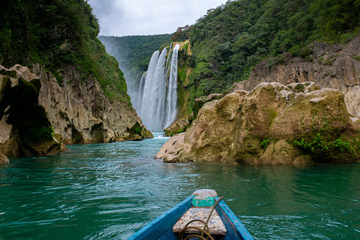 A canoe in front of a waterfall