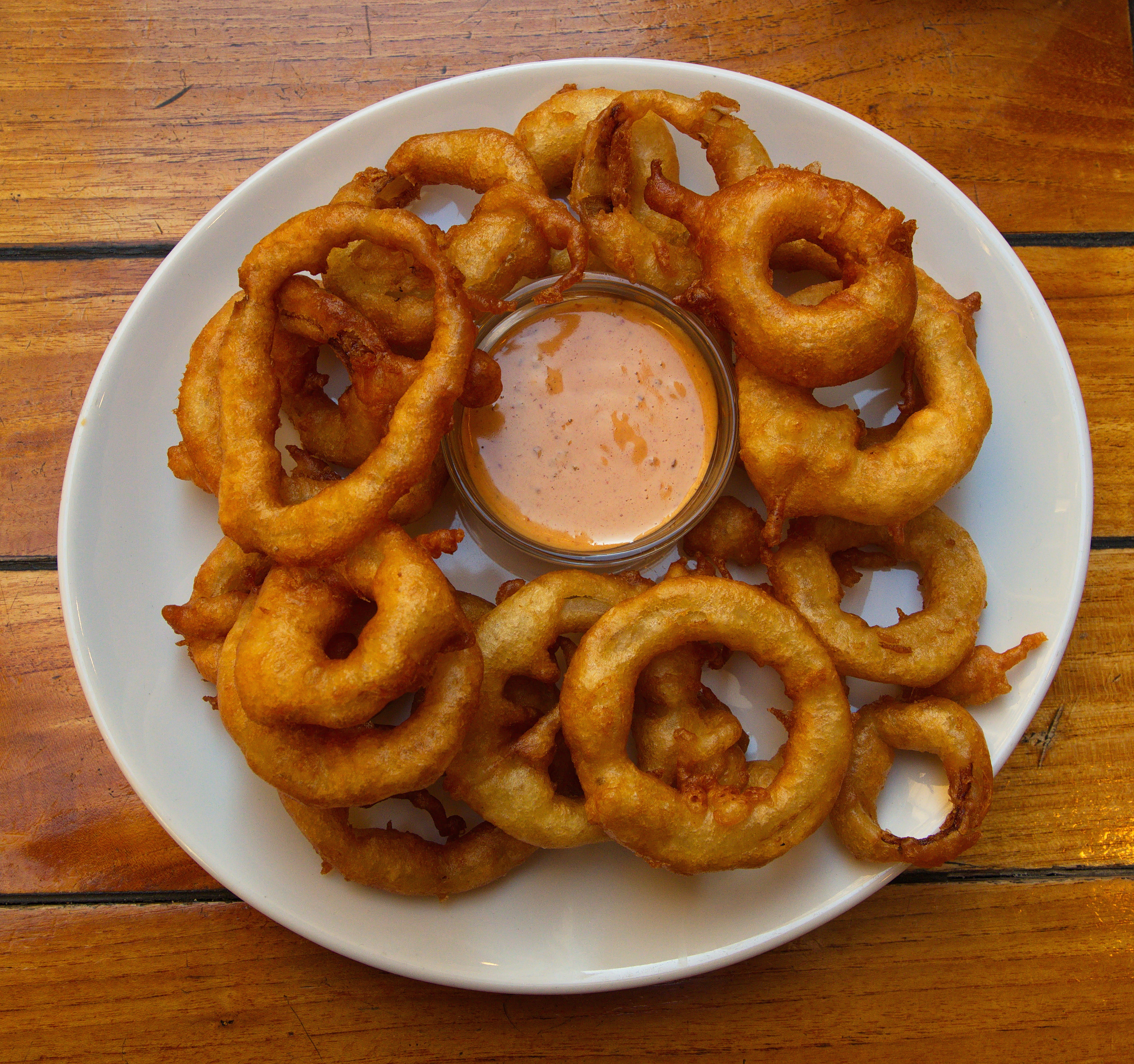 a plate of onion rings and dip