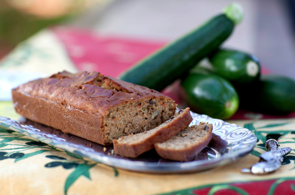 a loaf of zucchini bread next to zucchinis