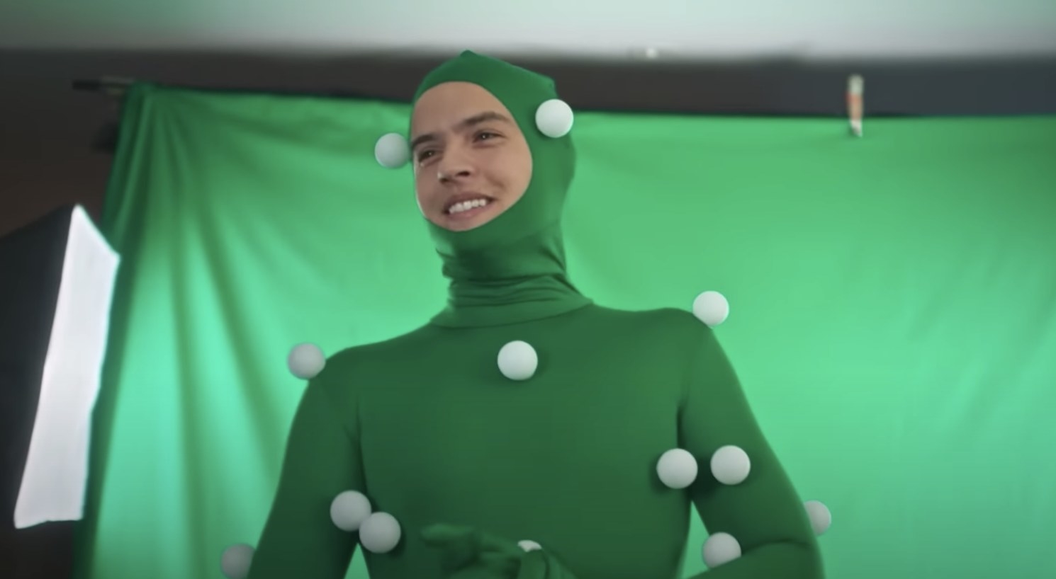 Dylan Sprouse in a motion capture suit in front of a green screen