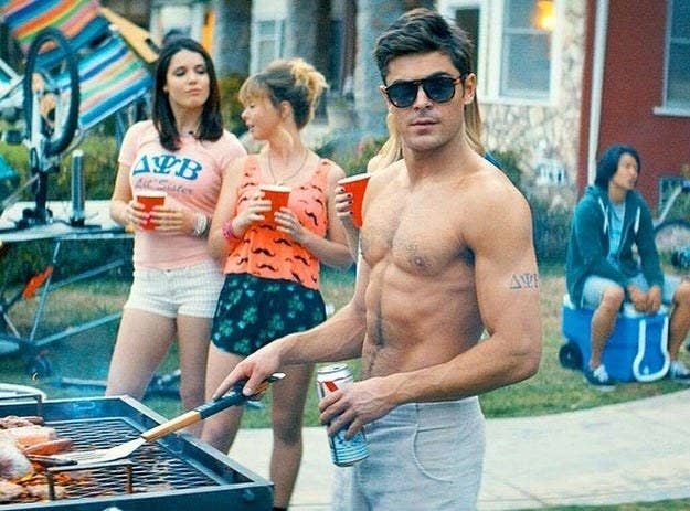 A man barbecuing while holding a beer.