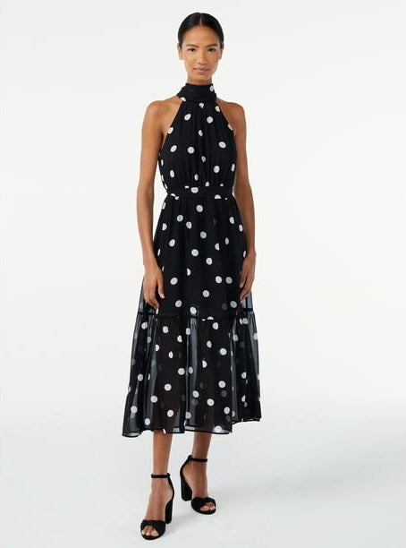 Model wearing black halter dress with white polka dots