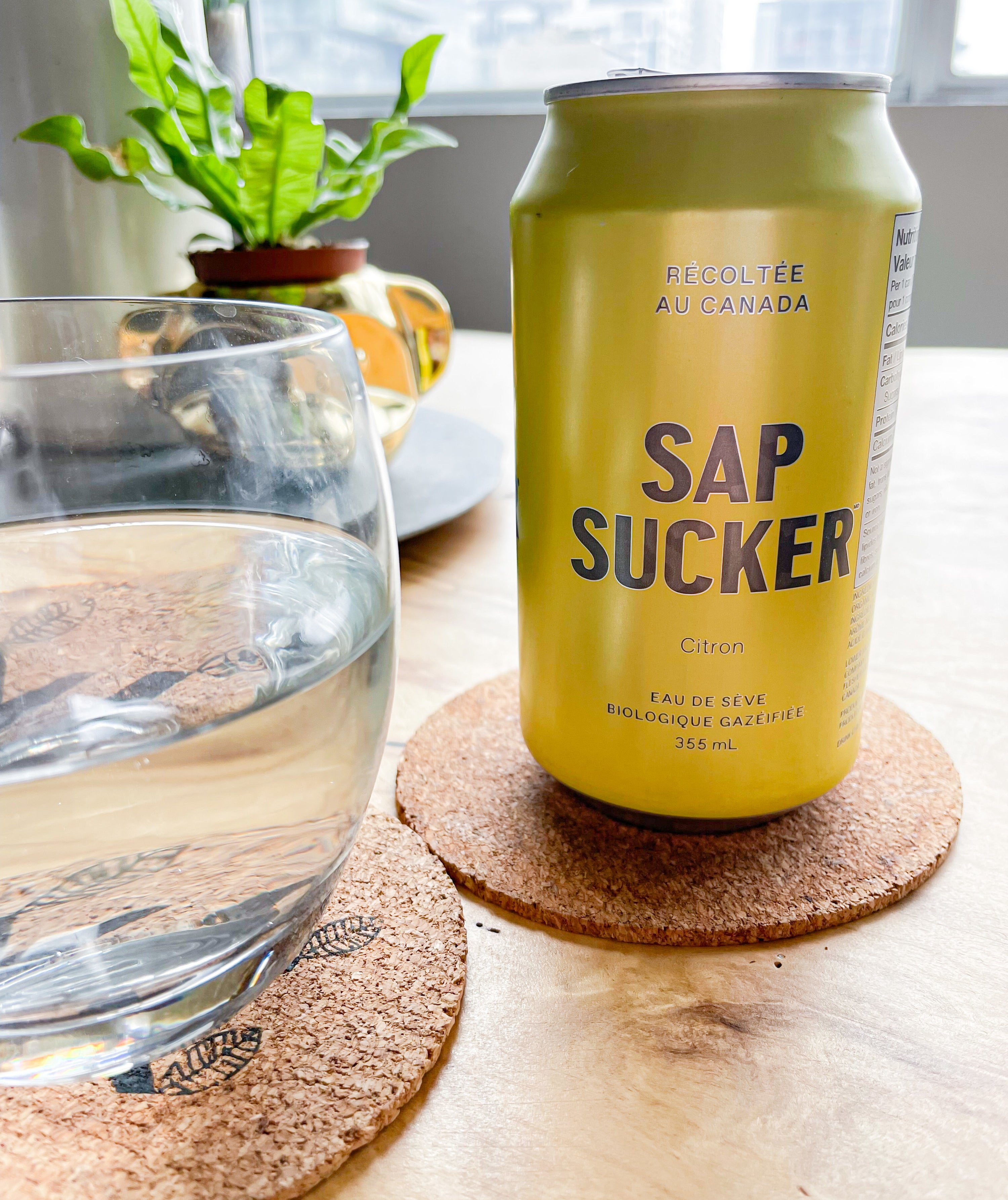 a open can of sap sucker next to a glass full of it