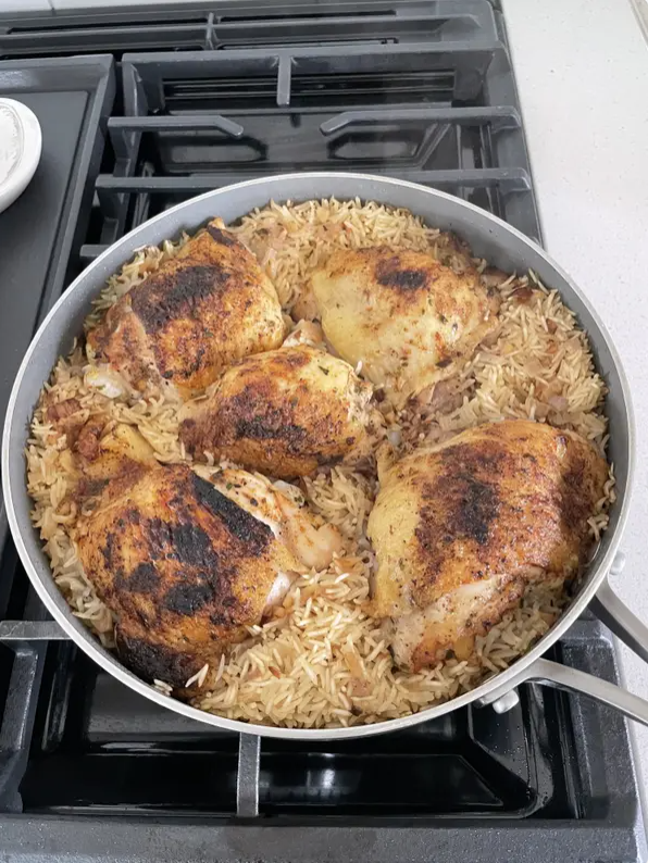 Chicken thighs and rice in a skillet.
