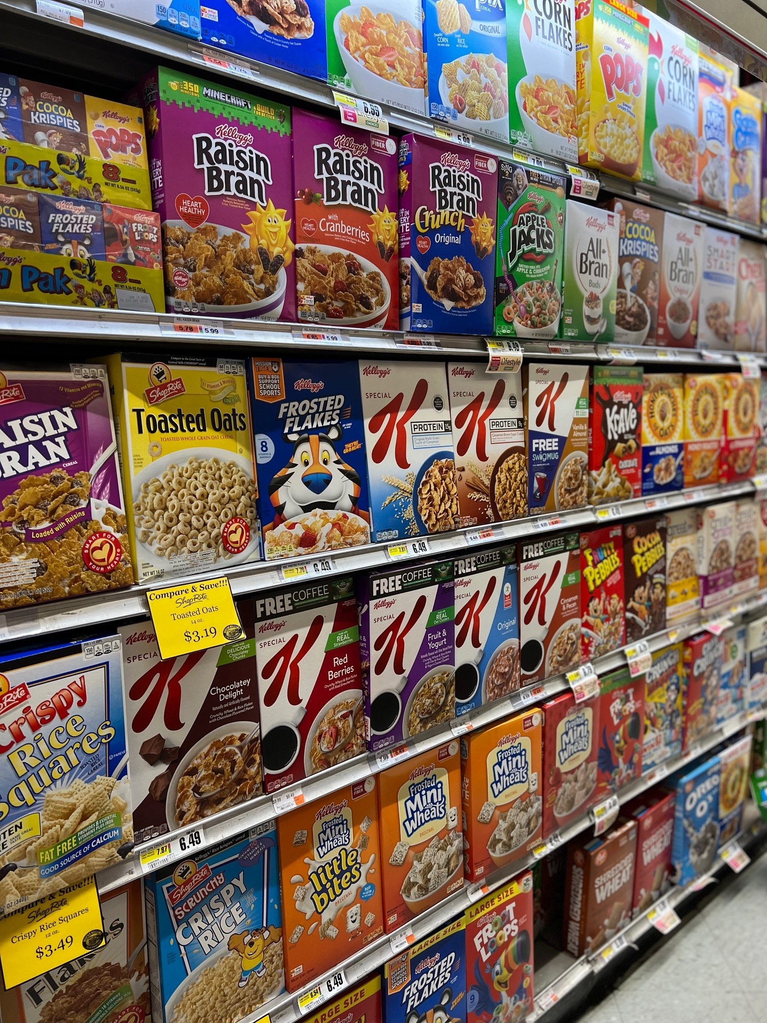 A grocery aisle with many rows of cereal