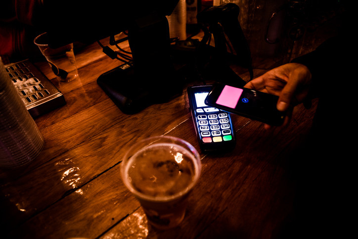 someone paying for a drink with their phone
