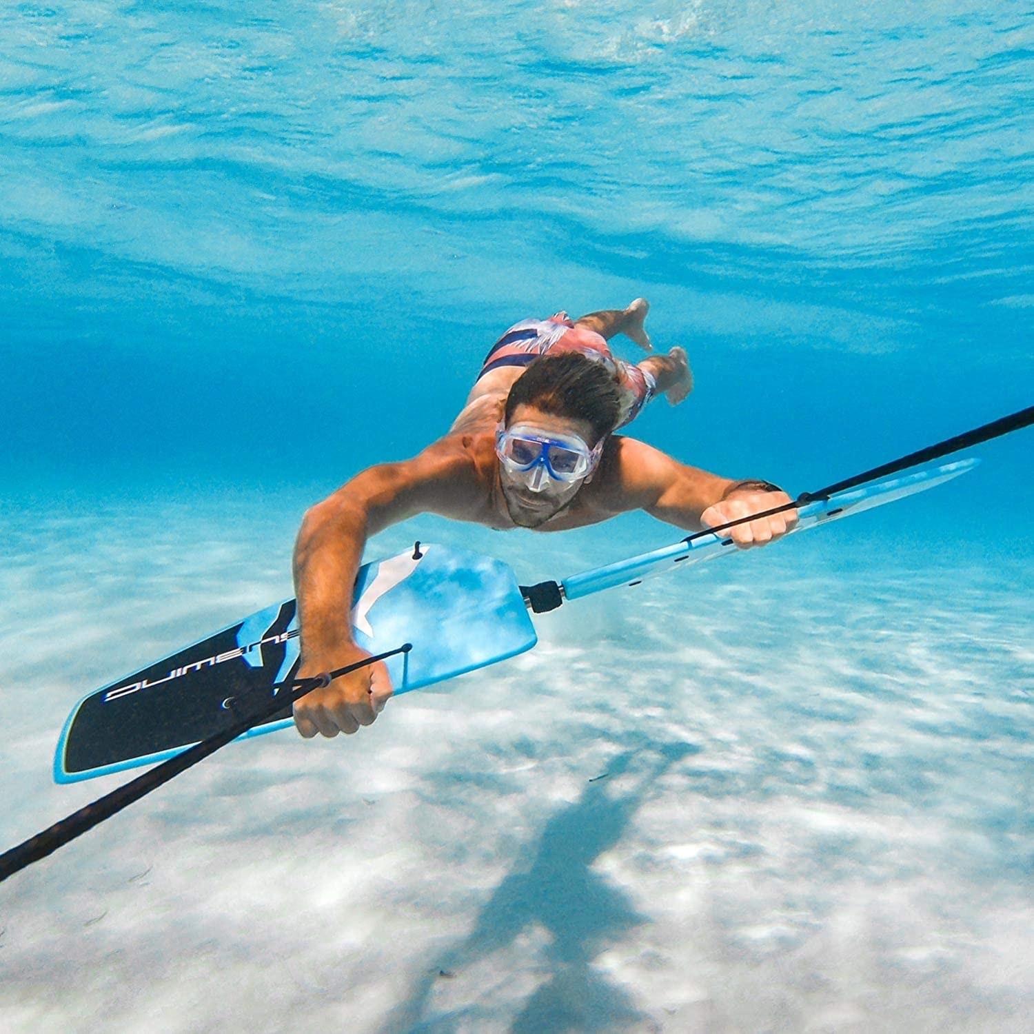 A person being pulled underwater while holding on to the board