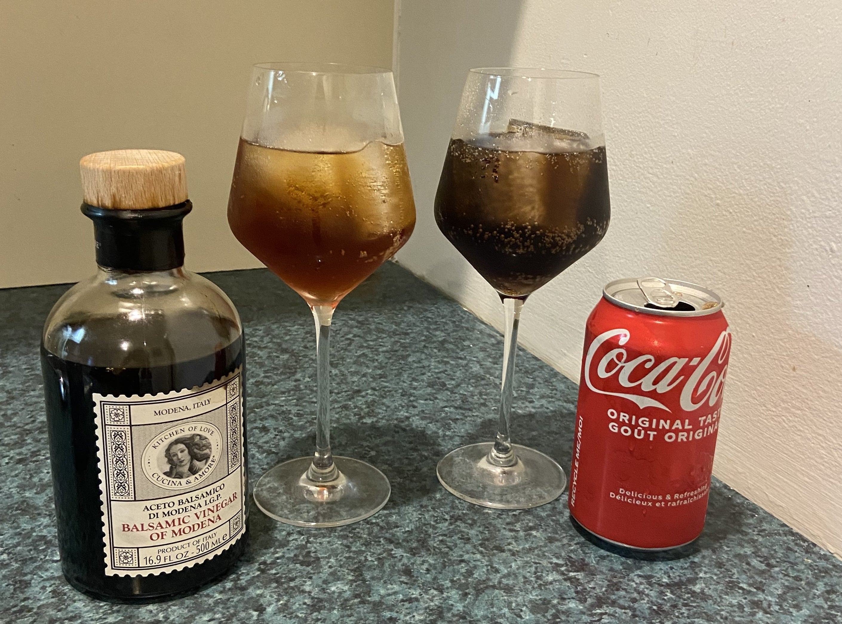 The glass of ice, vinegar, and La Croix next to a glass of Coke, which looks darker