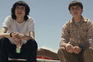 Mike Wheeler sits next to Will Byers as they sit on the hood of a car
