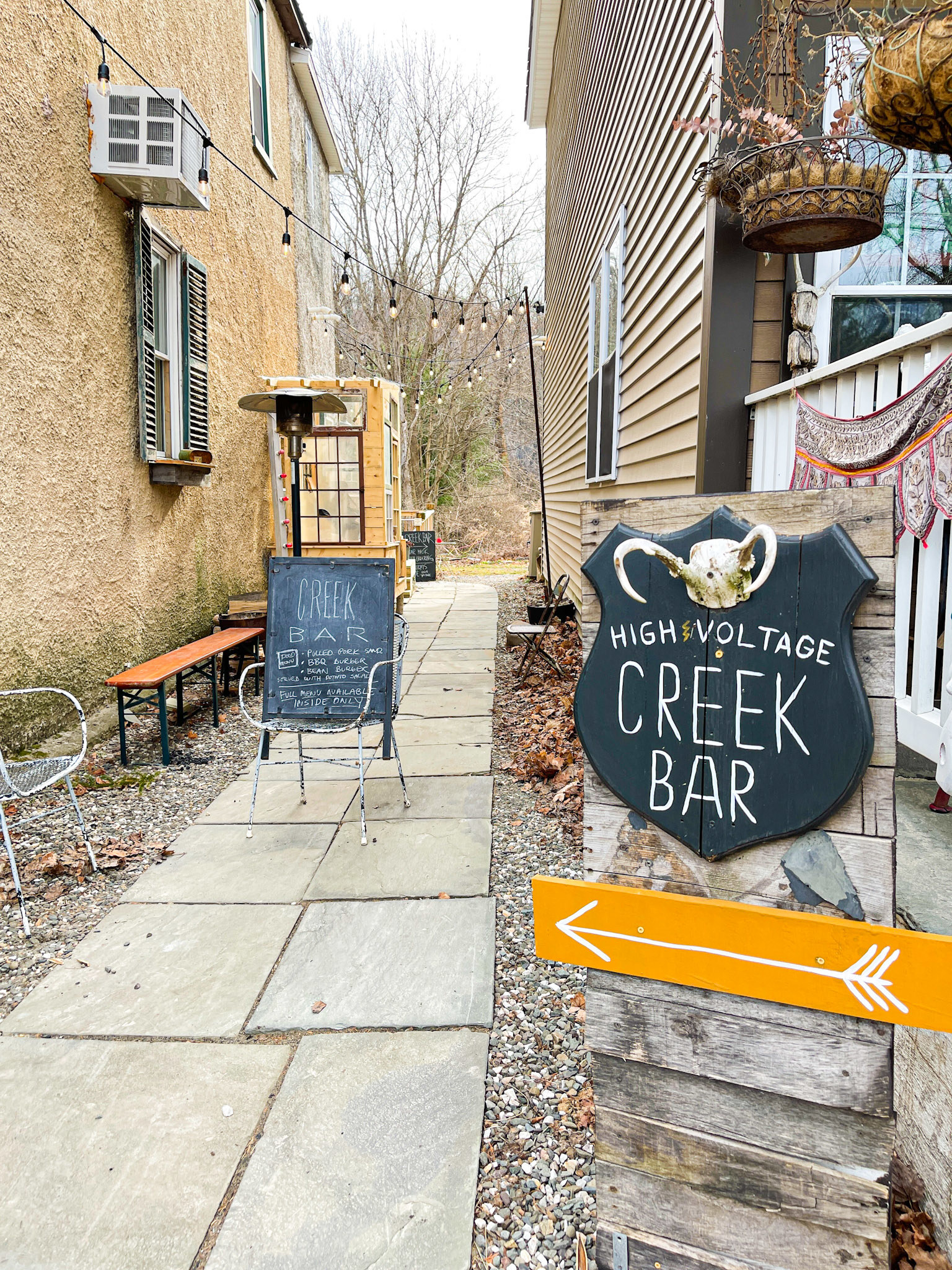 High Voltage Creek Bar exterior with an arrow pointing to the side/rear of the restaurant