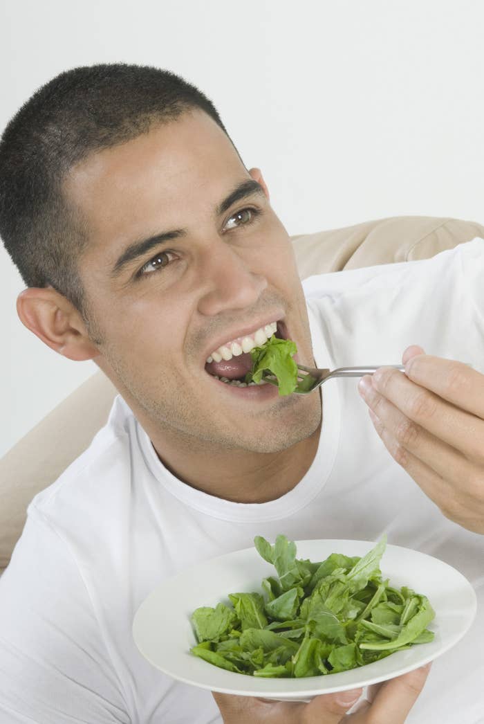 A man eating fresh greens