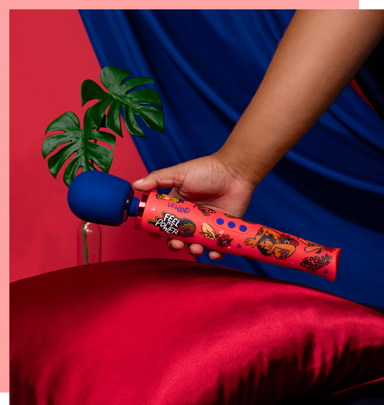 Model holding orange and blue designer wand vibrator