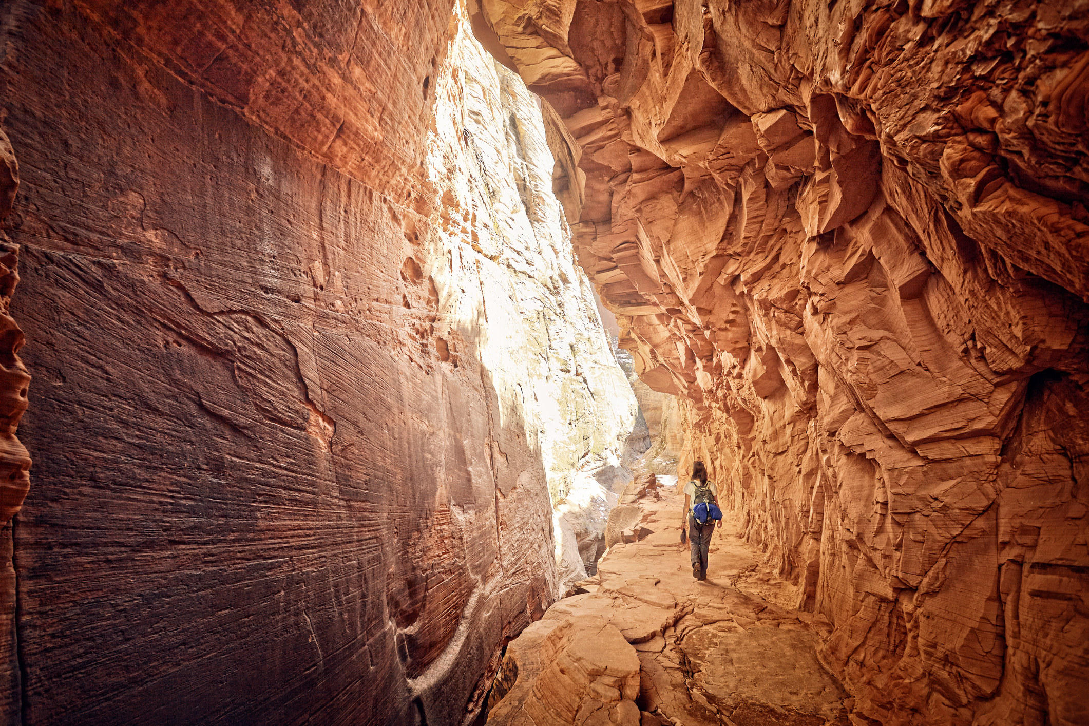一个孤独的女徒步旅行者穿过槽峡谷。