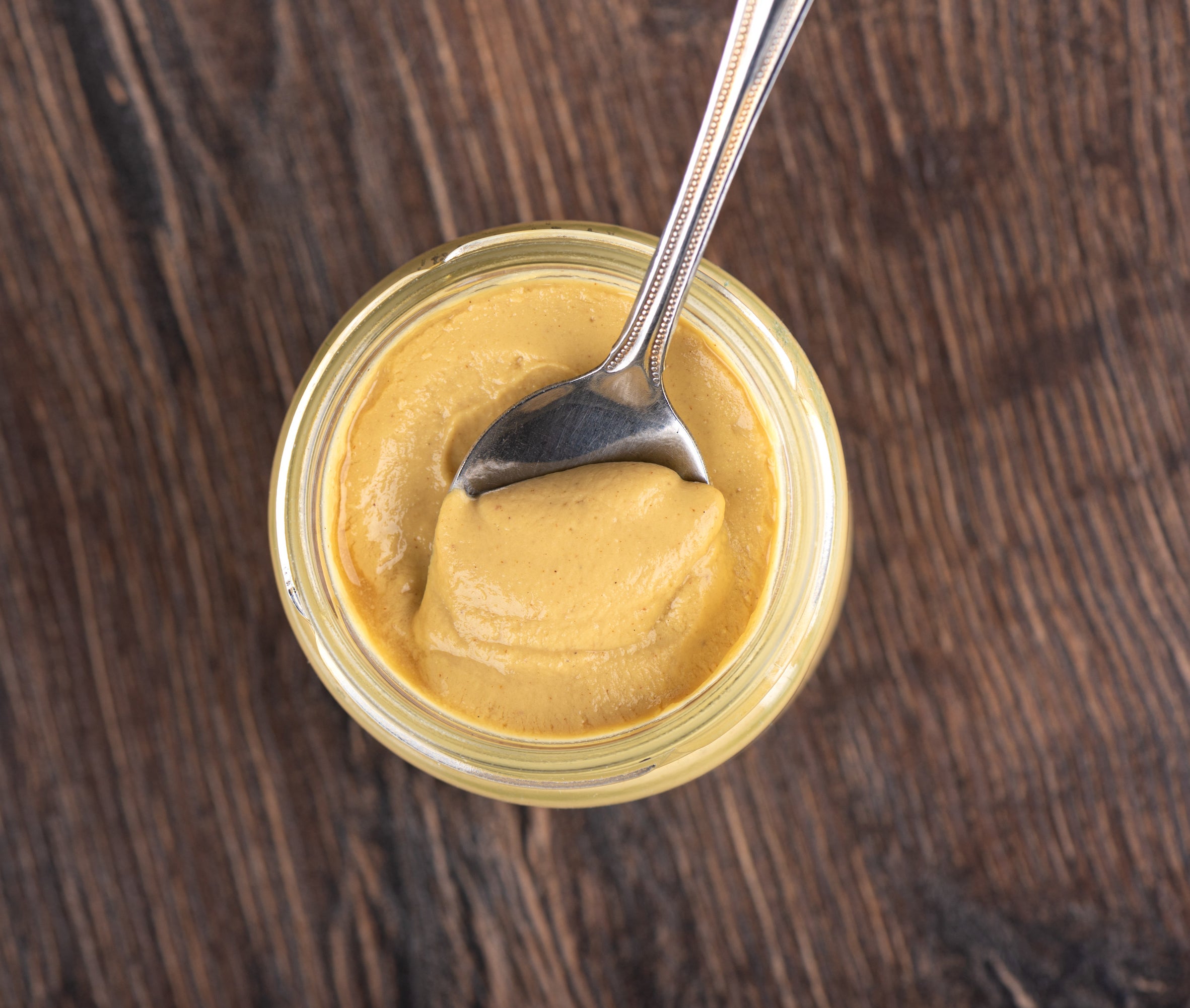 a jar of Dijon mustard with a spoon in it