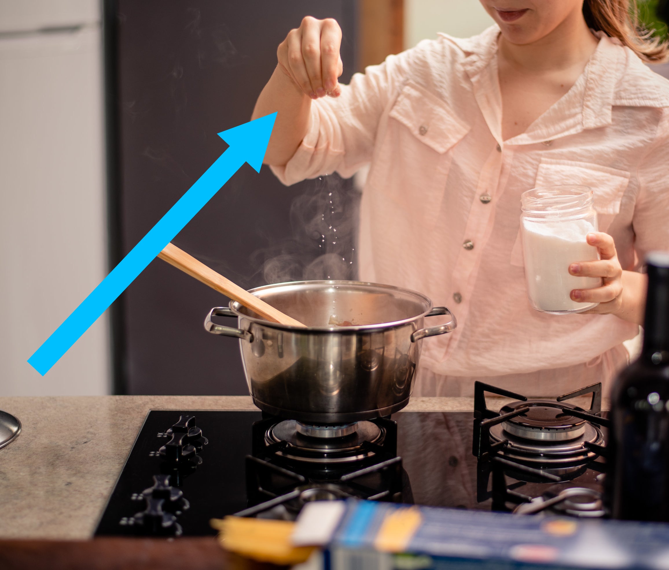 a person sprinkling sugar into a pot