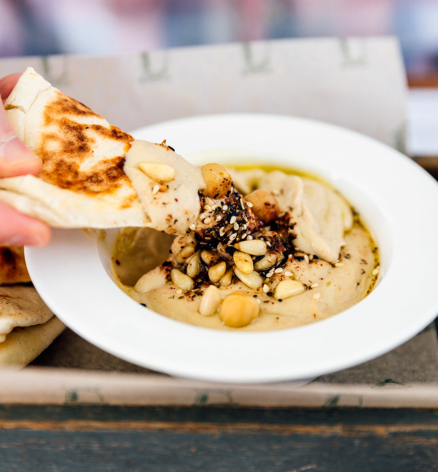 pita being dipped into hummus